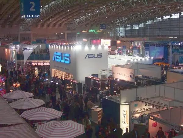 Large trade-fair hall crowd (illustrative image for peak-time planning)